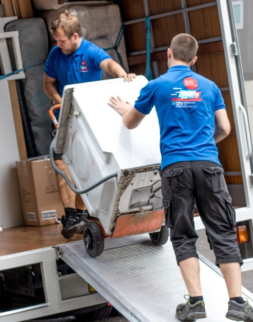 two expert furniture movers holding a fridge that is moving into a home