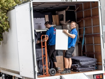 two abc removalist experts coordinating a complex commercial removals job in the daytime